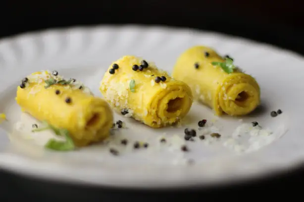 Foto von Khandvi - Zarte Gujarati Kichererbsen-Röllchen – fertig angerichtet