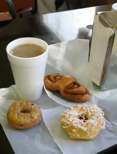 Foto von Klassische glasierte Donuts mit frischem Filterkaffee – fertig angerichtet